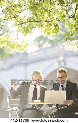 Businessmen working at sidewalk cafe View Large Photo Image Stock Photo - Businessmen working at sidewalk cafe. Fotosearch