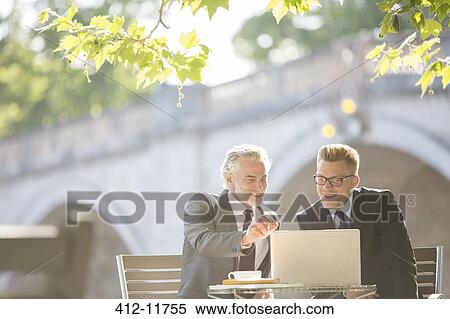Businessmen working at sidewalk cafe View Large Photo Image Stock Photography - Businessmen working at sidewalk cafe. Fotosearch