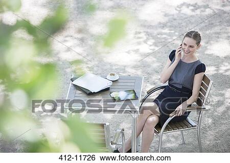 Businesswoman sitting at sidewalk cafe View Large Photo Image Stock Photograph - Businesswoman sitting at sidewalk cafe. Fotosearch