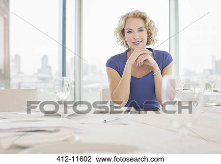 Stock Image - Businesswoman sitting in restaurant. Fotosearch