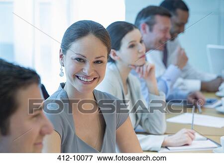 Businesswoman smiling in meeting View Large Photo Image Stock Photo - Businesswoman smiling in meeting. Fotosearch