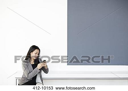 Businesswoman using cell phone in office View Large Photo Image Stock Image - Businesswoman using cell phone in office. Fotosearch