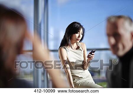 Businesswoman using cell phone in office View Large Photo Image Stock Photo - Businesswoman using cell phone in office. Fotosearch
