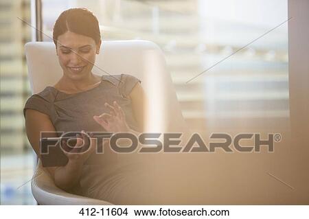 Picture - Businesswoman using digital tablet in office. Fotosearch