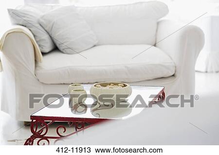 Stock Image - Candles on coffee table in living room. Fotosearch