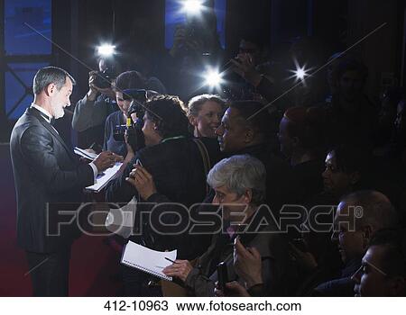 Stock Image - Celebrity signing autographs on red carpet. Fotosearch
