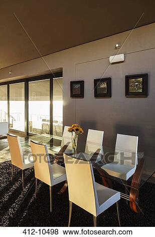Stock Photo - Chairs and table in modern dining room. Fotosearch