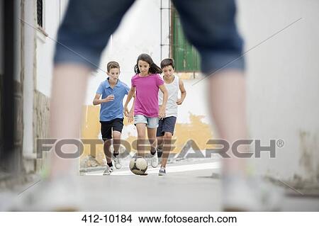 Children playing with soccer ball in alley View Large Photo Image Picture - Children playing with soccer ball in alley. Fotosearch