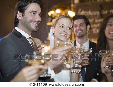 Stock Photo - Close up of bride and groom toasting champagne glasses. Fotosearch