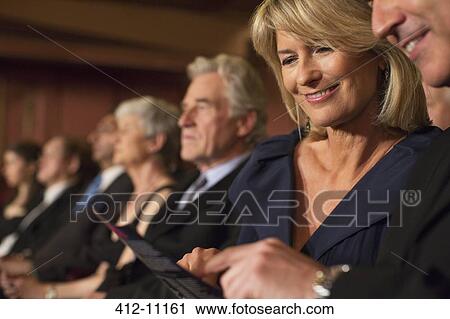 Close up of couple looking at playbill in theater audience View Large Photo Image Stock Image - Close up of couple looking at playbill in theater audience. Fotosearch