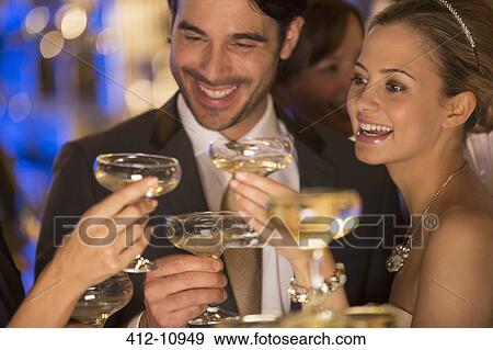 Stock Photo - Close up of couple toasting champagne glasses. Fotosearch