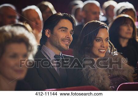 Picture - Close up of smiling couple in theater audience. Fotosearch