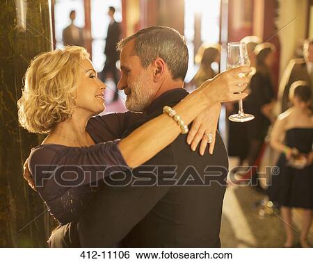 Stock Photograph - Close up of well dressed couple hugging in theater lobby. Fotosearch