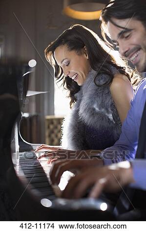 Close up of well dressed couple playing piano View Large Photo Image Picture - Close up of well dressed couple playing piano. Fotosearch