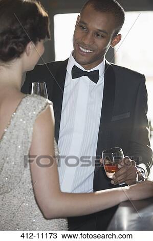 Close up of well dressed couple drinking cocktails in bar View Large Photo Image Stock Image - Close up of well dressed couple drinking cocktails in bar. Fotosearch