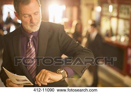 Close up of well dressed man with playbill checking the time in theater lobby View Large Photo Image Stock Image - Close up of well dressed man with playbill checking the time in theater lobby. Fotosearch