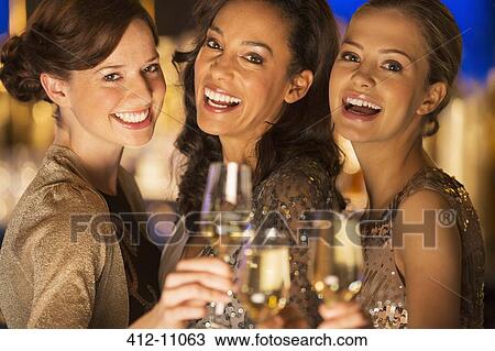 Close up portrait of smiling women toasting champagne flutes View Large Photo Image Stock Image - Close up portrait of smiling women toasting champagne flutes. Fotosearch
