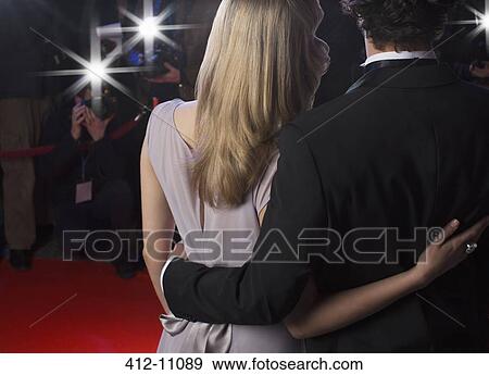 Stock Photo - Close up rear view of celebrity couple hugging for paparazzi on red carpet. Fotosearch
