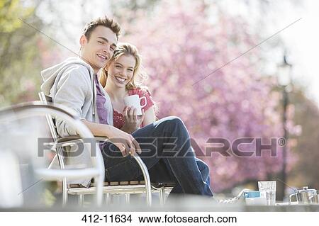 Picture - Couple having coffee on park bench. Fotosearch