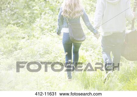 Couple holding hands in park View Large Photo Image Stock Image - Couple holding hands in park. Fotosearch