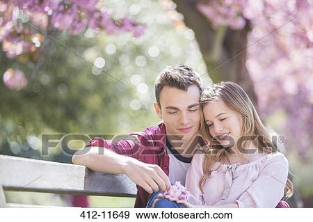 Stock Photo - Couple hugging on park bench. Fotosearch