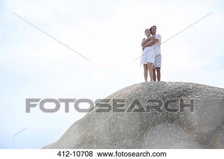 Couple hugging on rock formation View Large Photo Image Stock Photo - Couple hugging on rock formation. Fotosearch