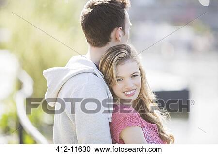 Stock Image - Couple hugging outdoors. Fotosearch