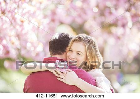 Couple hugging under tree with pink blossoms View Large Photo Image Stock Image - Couple hugging under tree with pink blossoms. Fotosearch