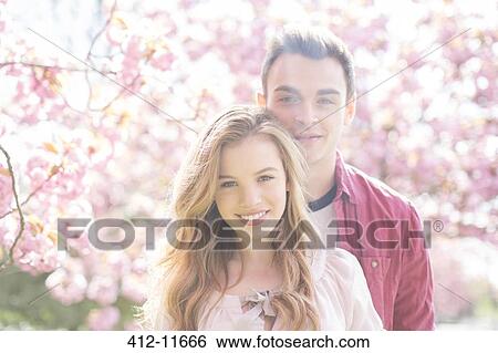 Couple hugging under tree with pink blossoms View Large Photo Image Stock Photograph - Couple hugging under tree with pink blossoms. Fotosearch