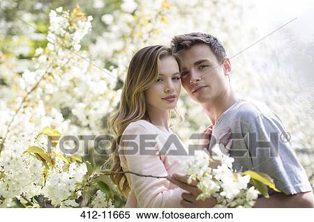 Couple hugging under tree with white blossoms View Large Photo Image Stock Photography - Couple hugging under tree with white blossoms. Fotosearch