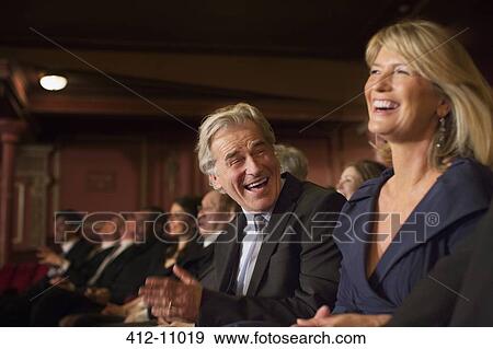 Stock Photo - Couple laughing and clapping in theater. Fotosearch