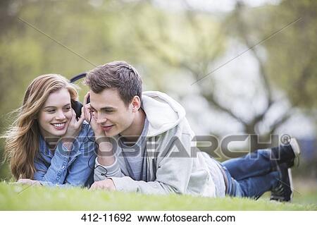 Couple listening to headphones in park View Large Photo Image Stock Image - Couple listening to headphones in park. Fotosearch