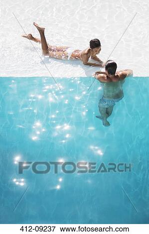 Couple relaxing in swimming pool View Large Photo Image Stock Photo - Couple relaxing in swimming pool. Fotosearch