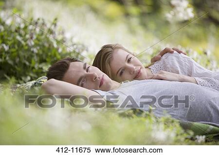 Stock Photography - Couple relaxing together in grass. Fotosearch
