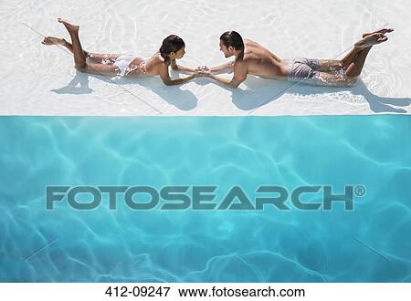 Stock Photo - Couple relaxing together in swimming pool. Fotosearch