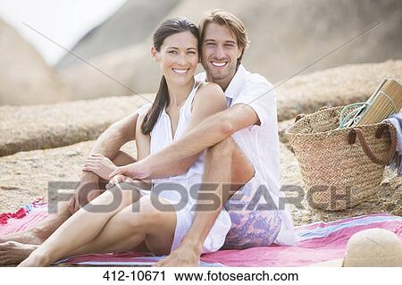 Couple relaxing together on beach View Large Photo Image Stock Image - Couple relaxing together on beach. Fotosearch