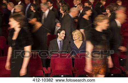 Couple sitting among people leaving theater View Large Photo Image Stock Image - Couple sitting among people leaving theater. Fotosearch