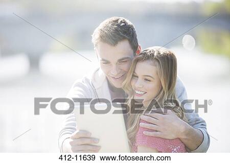 Couple using digital tablet outdoors View Large Photo Image Stock Photo - Couple using digital tablet outdoors. Fotosearch