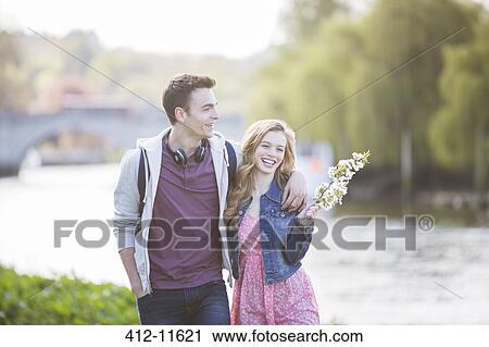 Couple walking along river View Large Photo Image Stock Image - Couple walking along river. Fotosearch