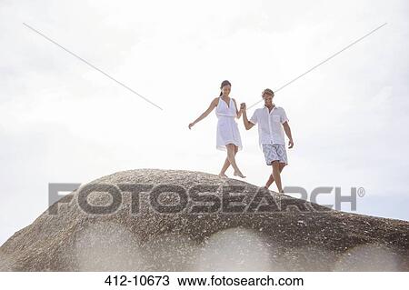 Couple walking on rock formation View Large Photo Image Stock Image - Couple walking on rock formation. Fotosearch
