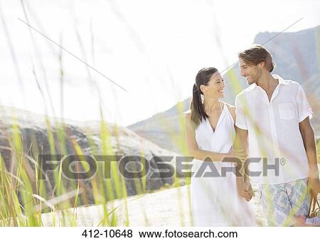 Couple walking together by beach View Large Photo Image Stock Photo - Couple walking together by beach. Fotosearch