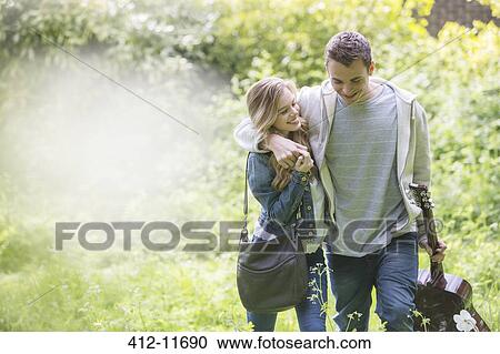 Couple with guitar walking in park View Large Photo Image Stock Image - Couple with guitar walking in park. Fotosearch