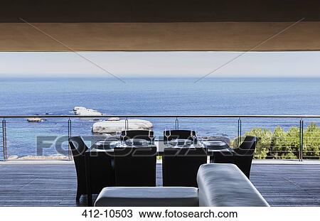 Dining table on luxury balcony overlooking ocean View Large Photo Image Stock Image - Dining table on luxury balcony overlooking ocean. Fotosearch