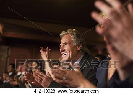 Stock Photo - Enthusiastic man clapping in theater audience. Fotosearch