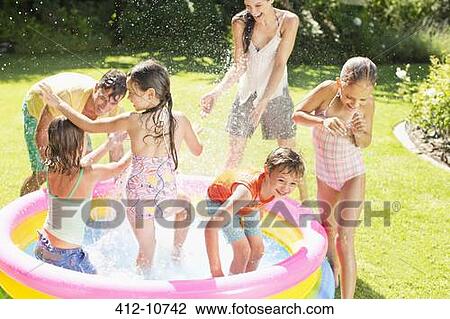Family playing in paddling pool in backyard View Large Photo Image Stock Image - Family playing in paddling pool in backyard. Fotosearch