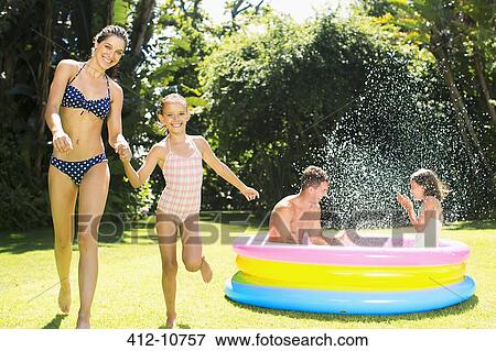 Stock Photo - Family playing together in backyard. Fotosearch