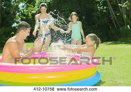 Family playing together in backyard View Large Photo Image Stock Photo - Family playing together in backyard. Fotosearch