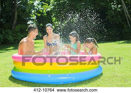 Family playing together in wading pool View Large Photo Image Picture - Family playing together in wading pool. Fotosearch