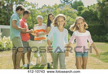 Stock Image - Family relaxing together in backyard. Fotosearch