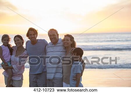 Family smiling together on beach View Large Photo Image Stock Image - Family smiling together on beach. Fotosearch